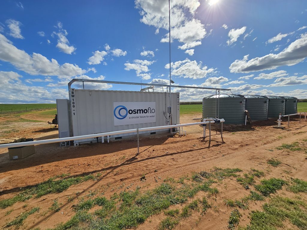 An OsmoFlo shipping container connected to water tanks.